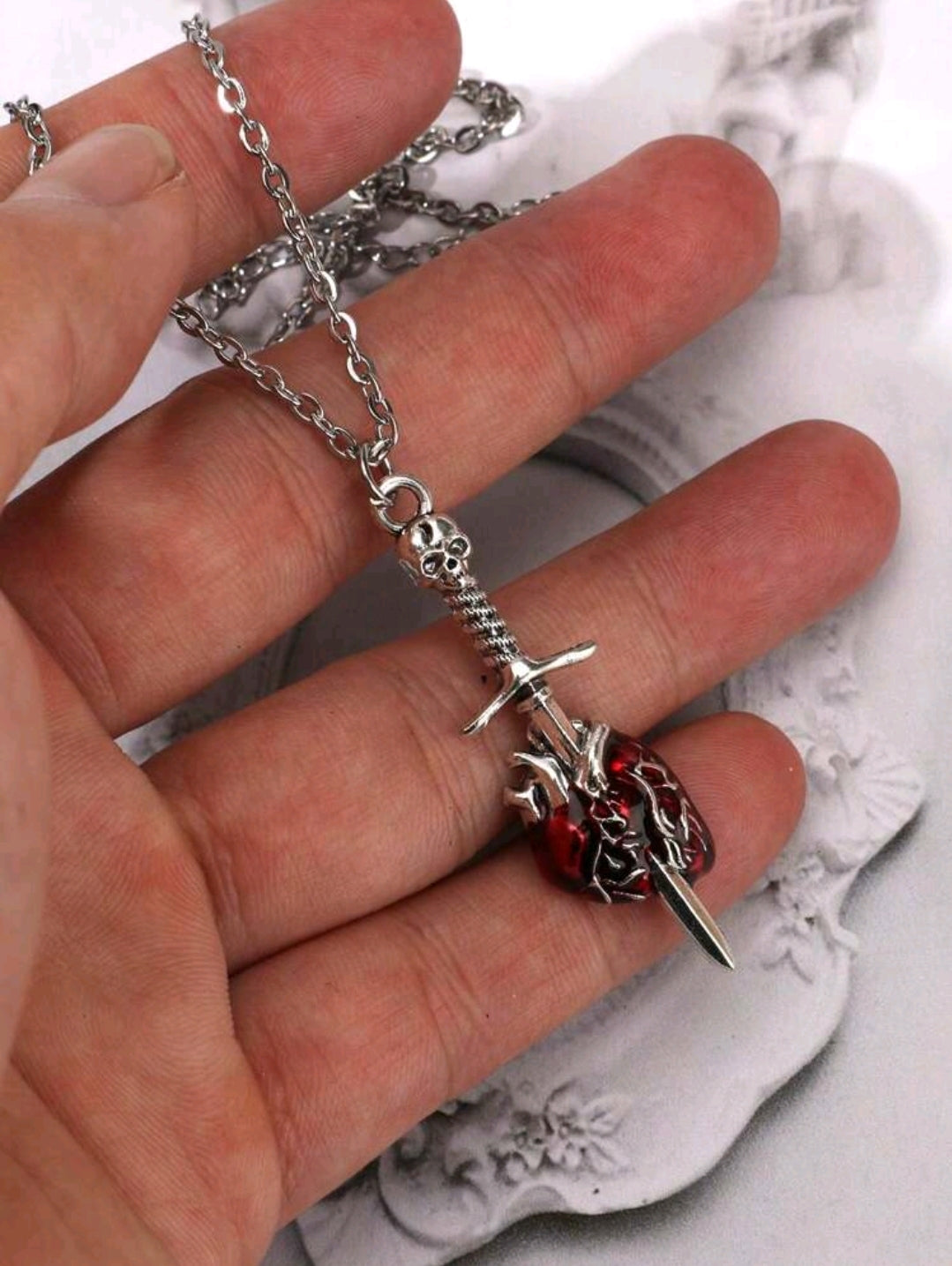 Necklace of a heart pierced by a sword